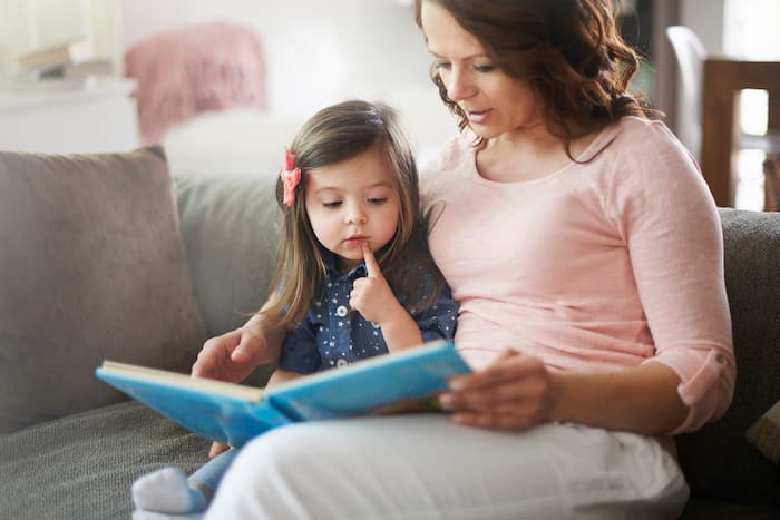 Mother and daughter reading a book together — reinforcing ABA therapy strategies at home